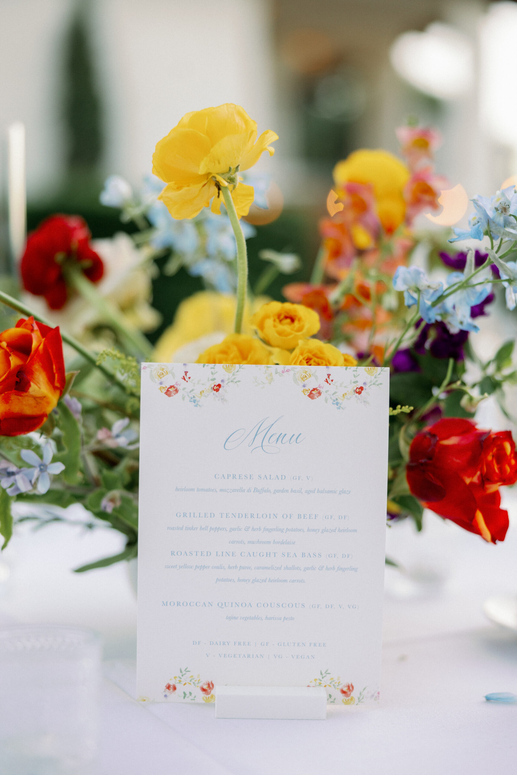 floral watercolor wedding menu with bright flowers in the background