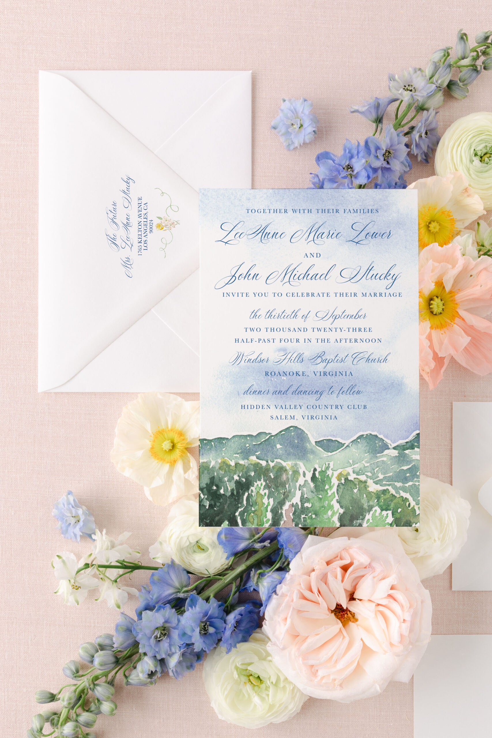watercolor wedding invitation on a pink background with flowers